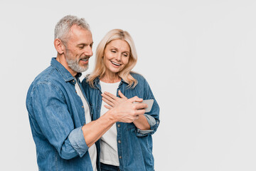 Positive mature middle age family watch cute video on phone, man holding smartphone , isolated on white studio background copy empty space. Relationships, sale app, ad and offer, fun and video call