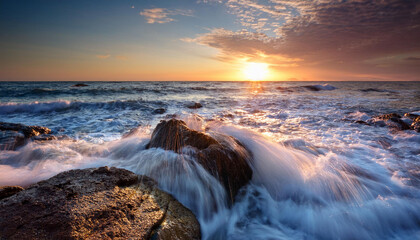 Obraz premium sea waves flowing line splash over rock on the seaside seascape earlier than sunrise