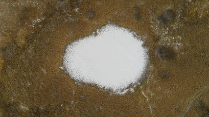 White circle is in the middle of a brown background. Frozen channels of the great Russian Volga River.