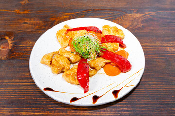 Delicious chicken dish with peppers and sauce on a wooden table Savory vegetable pie served