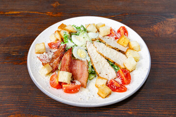 Fresh salad with grilled chicken, bacon, and croutons served on a plate Savory vegetable pie served with fresh garnishes