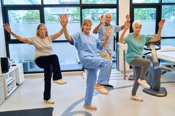 Group of seniors and trainer in an exercise session at rehabilitation center