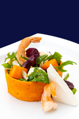 Colorful salad with shrimp, vegetables, and cheese on a white plate