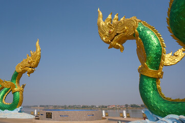 Two green serpent statues on the Mekong River