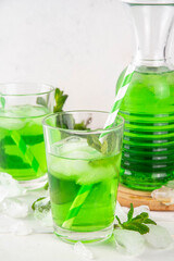 Middle Wastern limonana cocktail, mint liqueur lemonade, Lebanese mint lemonade drink, with crushed ice on white kitchen table background, copy space
