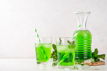 Middle Wastern limonana cocktail, mint liqueur lemonade, Lebanese mint lemonade drink, with crushed ice on white kitchen table background, copy space