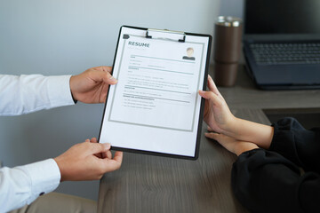 The executive is greeting new colleague, handshake while job interviewing, female candidate shaking hands with interviewer or employer after a job interview, employment and recruitment concept.