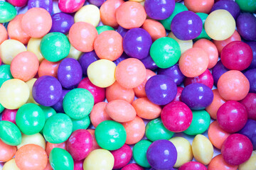 Closeup on pile of fruity gummy bears in pastel colours.