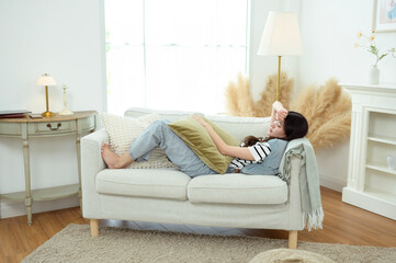 Young Asian woman relaxing in living room at home