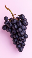 Fototapeta premium bunch of red grapes on a pink pastel background