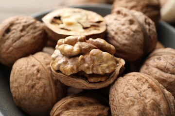 Fresh walnuts with shells on table, closeup