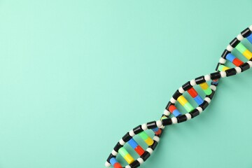 Colorful DNA structure model on turquoise background, top view. Space for text