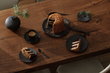 Dark chocolate handmade cake served on black plate on oak table