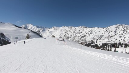 Winter Scene Of A Busy Ski Slope With Thrilling People Skiing Down Amidst Snowy Landscape