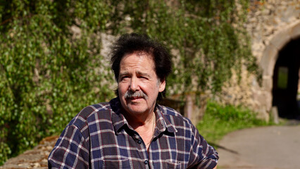 Attraktiver Mann steht vor dem Eingang zu einer Burg.


