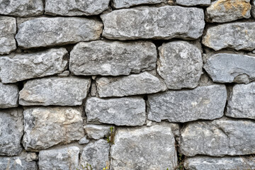Fototapeta premium Close-up of weathered gray stone surface, rough, uneven natural texture.