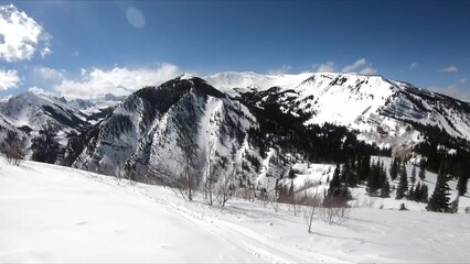 Serene Winter Landscape Featuring A Snowy Mountain, Sparce Trees, And Untouched Snow