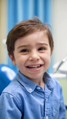 Young boy smiles happily while sitting in a dental chair during an appointment for a routine checkup
