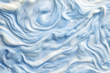 Fototapeta premium Macro shot of chambray blue sea foam on ocean waves, soft, frothy textures forming natural swirls.