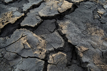 Rugged volcanic rock texture, dark black with sharp cracks and porous details, highlighting its rough, natural formation.