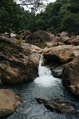 Misty Waterfall Over Massive Boulders