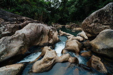Misty Waterfall Over Massive Boulders