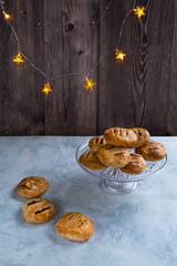 Home baked Eccles cakes on a table with fairy lights behind