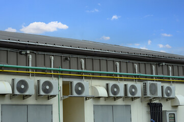 Air compressor or air condenser unit located on support outside building to heat released...