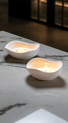 Soft glow from white candles on a marble table creating a serene atmosphere in a cozy space during the evening