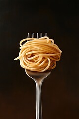 A fork elegantly holds a tangled and messy pile of spaghetti, set against a dark background that enhances the soft lighting