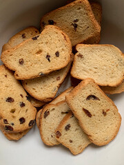 Golden brown toasted bread slices with raisins, showcasing a crispy texture and rustic baked...