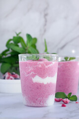a glass of mixed berry yogurt smoothie on marble table background. 