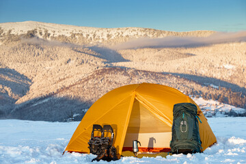 Overnight in a tent in the mountains in winter, camping equipment.