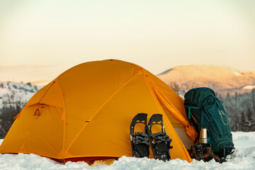 Overnight in a tent in the mountains in winter, camping equipment.