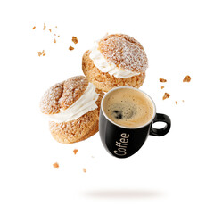 Black cofee cup, cream puffs, pastry from choux covered sugar powder with crumbs falling flying isolated on white background.