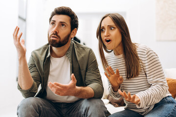 Young couple arguing and gesturing with hands at home