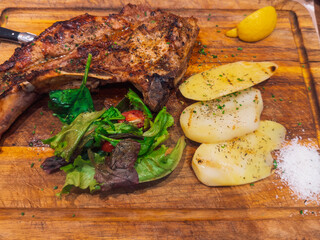 Savory grilled steak accompanied by fresh vegetables and lemon slice.