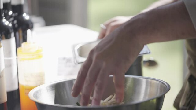 A silver bowl is filled with a mixture of ingredients. The bowl is placed on a counter next to a bottle of Vegemite