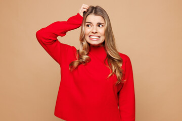Young sad dissatisfied mistaken shocked Caucasian woman she wear red casual clothes look aside on...
