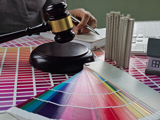 Legal professional preparing documents with color palettes and models at a desk in a contemporary...