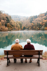 Elderly couple enjoying peaceful moments by lake in autumn nature setting