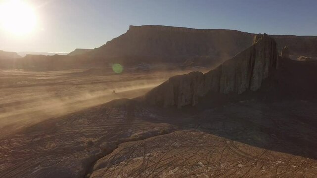 Majestic, cinematic aerial shot of Southern Utah desert with motorcyclists kicking up dirt