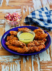 crispy fried chicken tenders served with a mustard dipping sauce on a cutting board