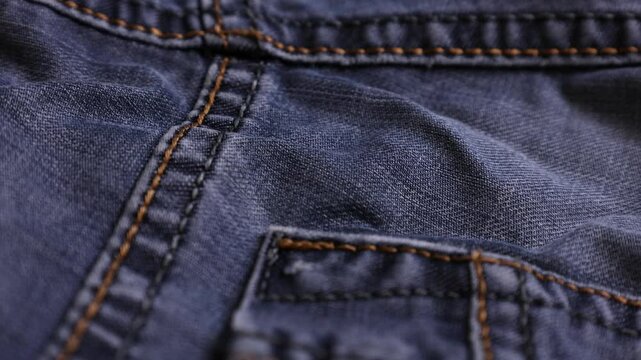 Close-up view of blue denim fabric showcasing detailed stitching and texture in well-structured design
