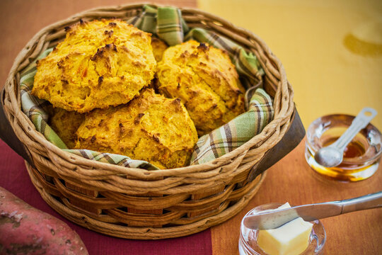 basket of sweet potato biscuits served with honey and butter