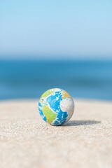 Obraz premium Exploring global connections coastal beach miniature earth globe serene seaside close-up view environmental awareness