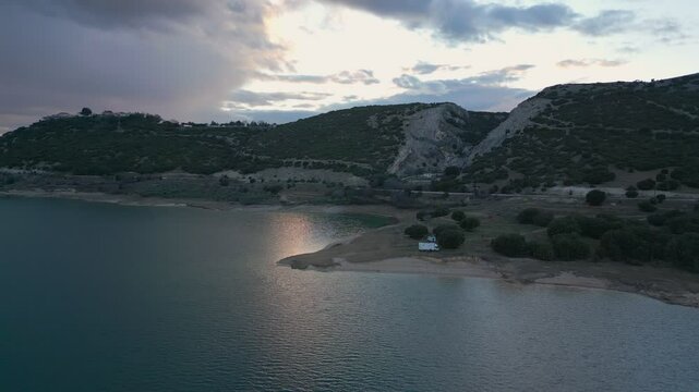 Camper vans parked on a wild spot in Lake Polyfyto drone aerial view at sunset in Greece