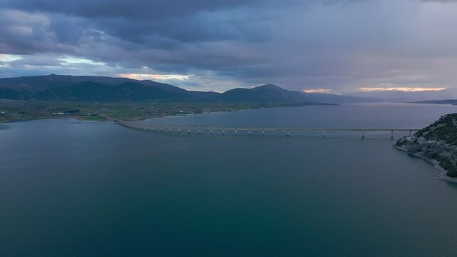 Lake Polyfyto mountain landscape and high bridge of Servia Neraida drone aerial view at sunset in Greece