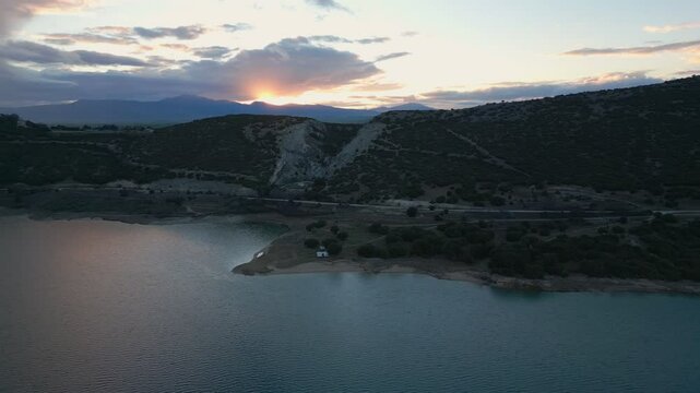 Camper vans parked on a wild spot in Lake Polyfyto drone aerial view at sunset in Greece
