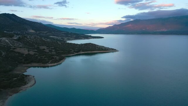 Lake Polyfyto mountain landscape drone aerial view in Greece at sunset